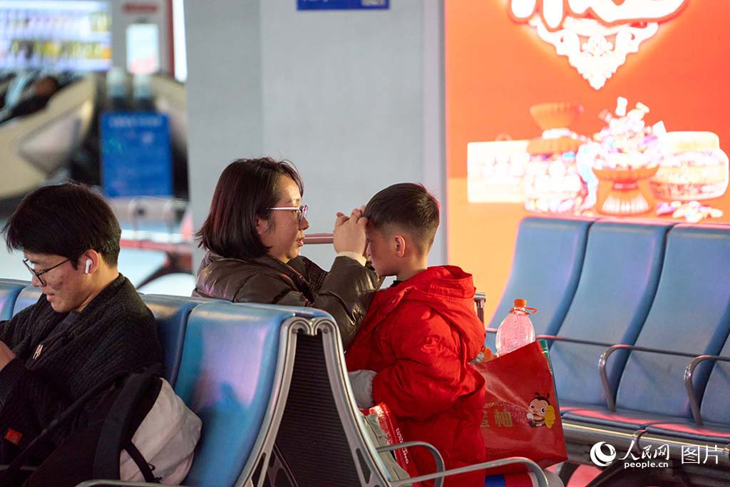 1月13日 太原南站，母亲帮孩子整理头发。人民网 张超宁摄